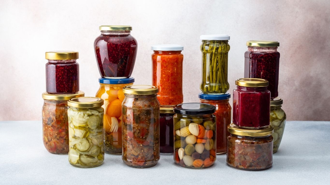 Jars of preserved foods on a surface, highlighting food-safe alternatives to glass bottles.